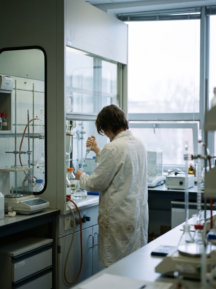 Analyst pipetting at a fume hood